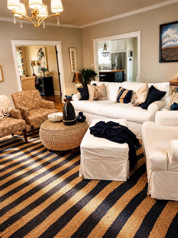 A living room features a striped rug, white sofa, patterned armchairs, and a round coffee table — 3922 NW 69TH STREET, GAINESVILLE, FL