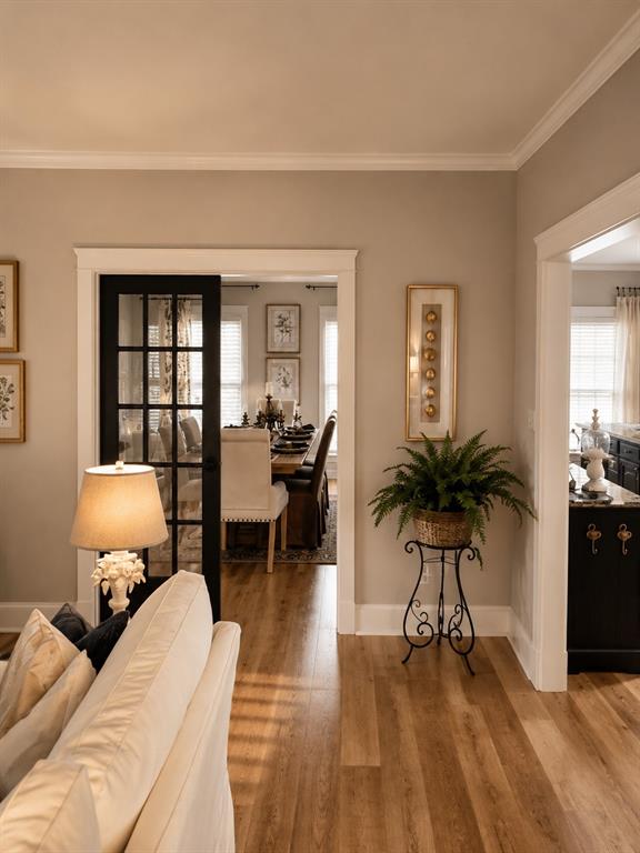 A living room with a white sofa and lamp leads into a dining room through doors — 3922 NW 69TH STREET, GAINESVILLE, FL