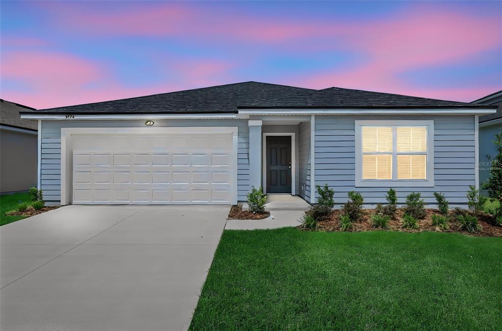 A single-story house with light blue siding, a two-car garage, and a front lawn — 5776 LAGOON CRUISE WAY, JACKSONVILLE, FL