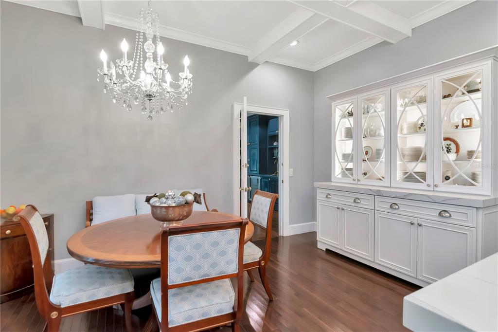 A dining room features a wooden table, upholstered chairs, a crystal chandelier, and a hutch — 6220 BAYSHORE BOULEVARD, TAMPA, FL