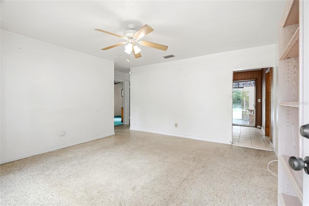 An empty room with white walls, a ceiling fan, and speckled flooring — 427 1ST AVENUE NE, LARGO, FL