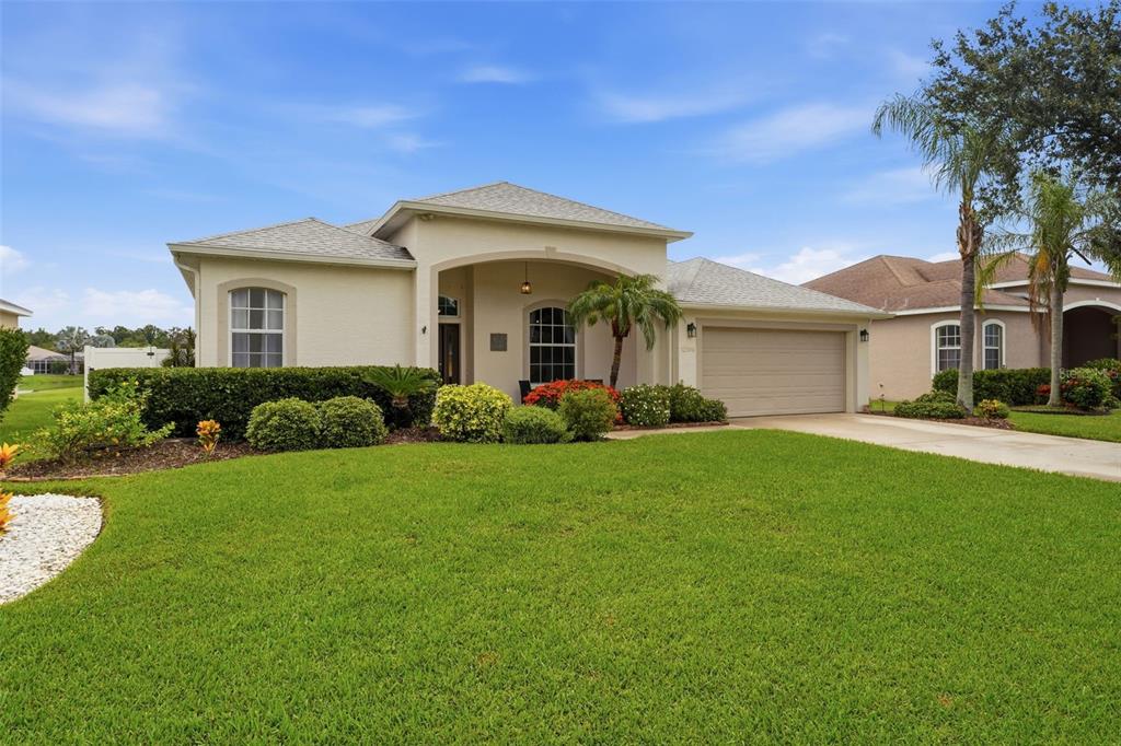 A single-story suburban house with a beige stucco exterior, a two-car garage, and landscaped lawn — 12506 25TH COURT E, PARRISH, FL