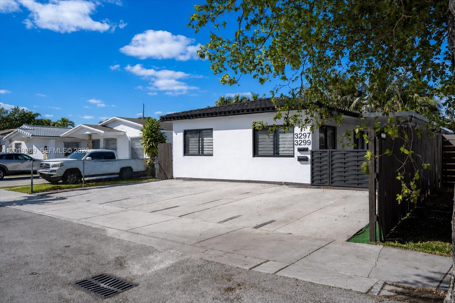 A white single-story house with a flat roof and a large concrete driveway — 3297 SW 26th St, Miami FL 33133, MIAMI, FL