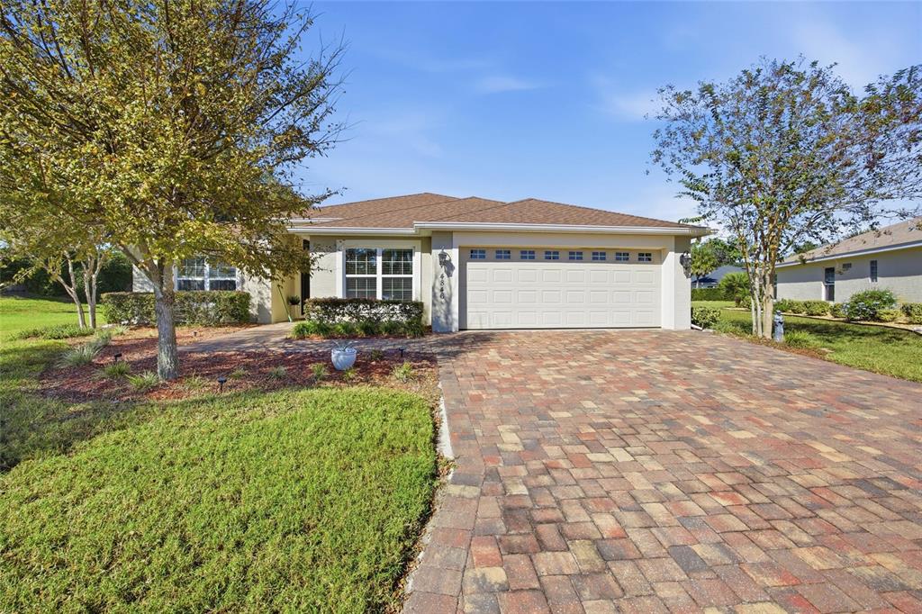 A single-story house with a paved driveway, a two-car garage, and a landscaped front yard — 4846 AUDREY MARIE COURT, OXFORD, FL