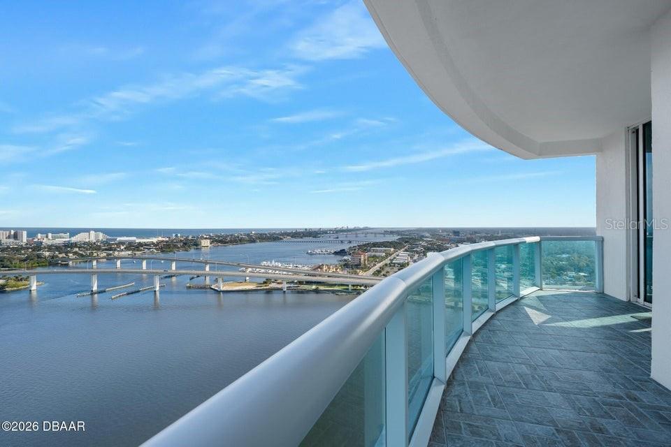 A high-rise balcony with a glass railing overlooks a bridge, a river, and the ocean — 231 RIVERSIDE DRIVE UNIT 2601-1, DAYTONA BEACH, FL