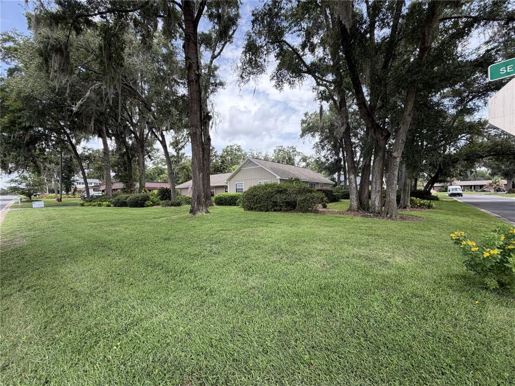 A single-story house sits on a large, grassy lot shaded by many mature oak trees — 3925 SE 17TH STREET, OCALA, FL