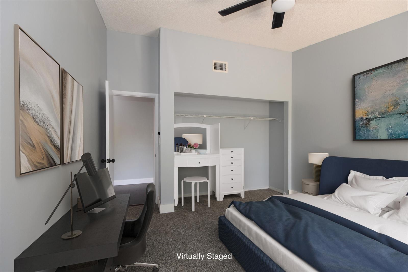This bedroom features a desk, a bed, a vanity, and a closet with gray walls — 5087 Oakhill Lane, Delray Beach FL 33484, DELRAY BEACH, FL
