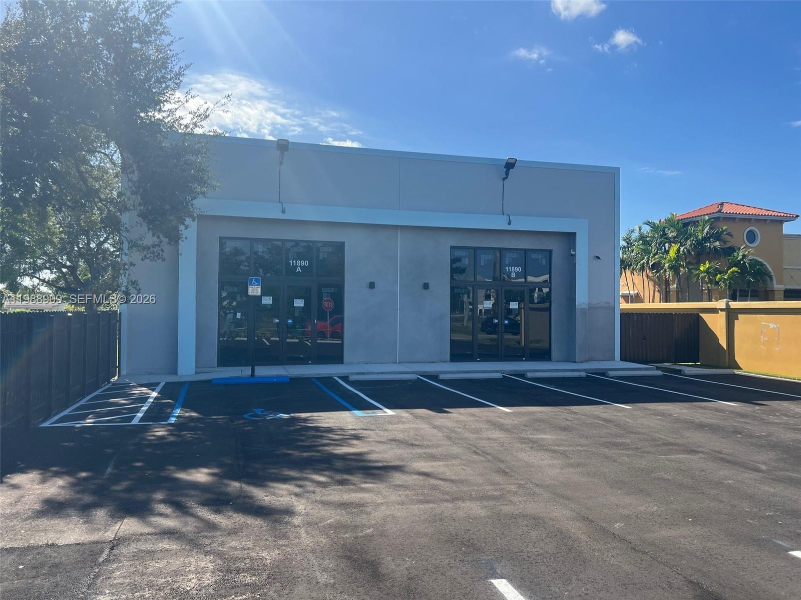 A single-story commercial building with two glass-front entrances and a paved parking lot — 11890 SW 220th St, Miami FL 33170, MIAMI, FL