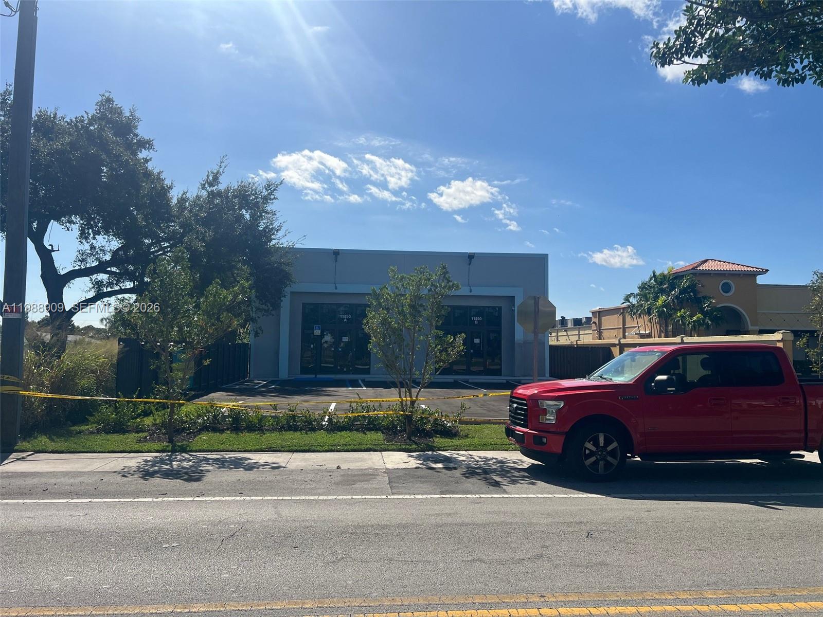 A red pickup truck is parked in front of a commercial building with two entrances — 11890 SW 220th St, Miami FL 33170, MIAMI, FL