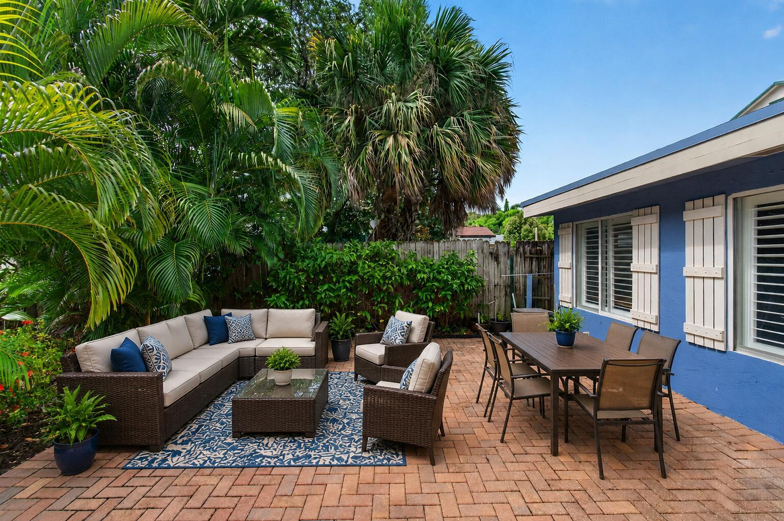 A patio with wicker furniture, a dining set, and a blue rug on brick pavers — 227 N M Street, FL 33460, FL