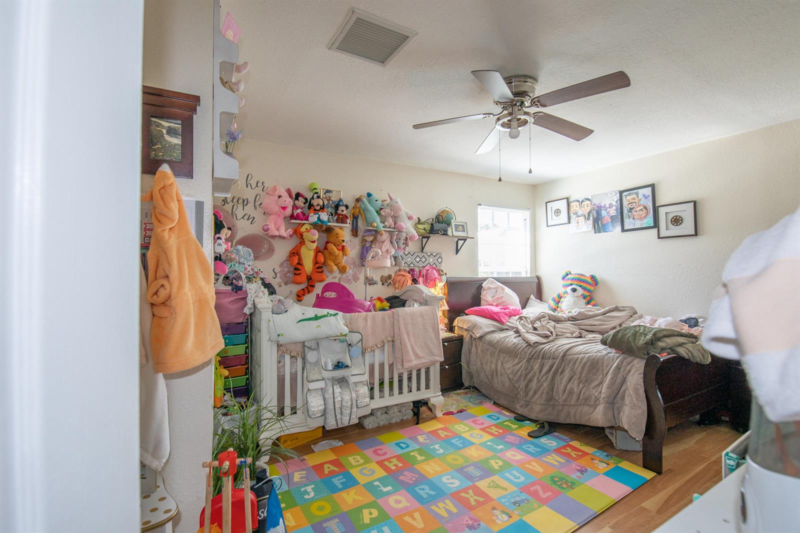 A child's bedroom features a crib, a bed, a colorful alphabet rug, and wall-mounted toys — 922 S Dixie Street, FL 33460, FL