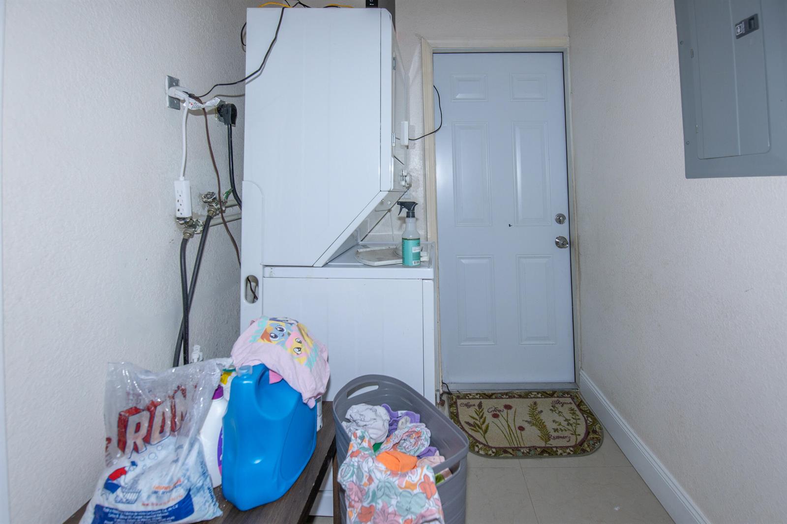 A laundry room features a stacked washer and dryer, a door, and a laundry basket — 922 S Dixie Street, FL 33460, FL