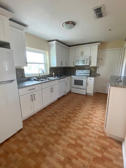 A kitchen with white cabinets, stainless steel appliances, and brown tiled flooring — 3131 LITTLE SOUND DRIVE, ORLANDO, FL