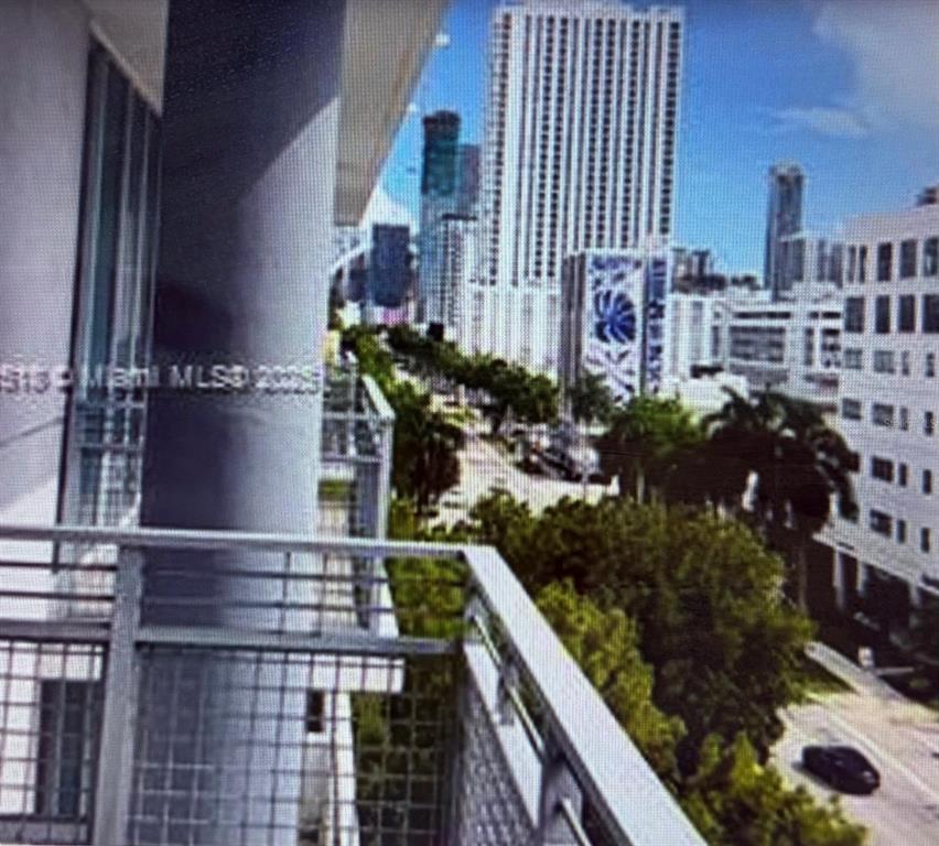A view from a balcony overlooking a city street with tall buildings and green trees — 350 NE 24TH STREET UNIT 514, MIAMI, FL