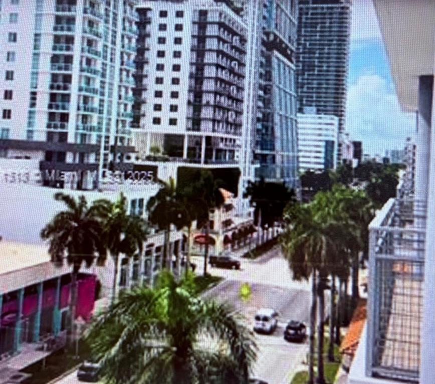 An elevated view of a city street lined with palm trees and modern high-rise buildings — 350 NE 24TH STREET UNIT 514, MIAMI, FL
