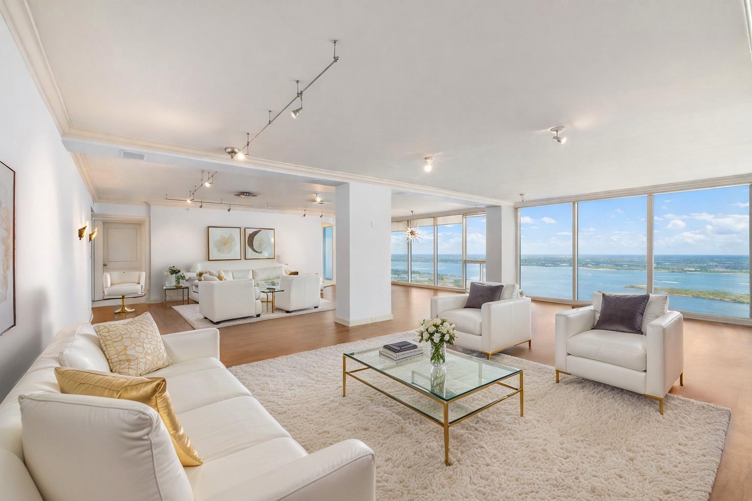 A spacious living room with white furniture, a glass coffee table, and floor-to-ceiling windows — 529 S Flagler Drive, West Palm Beach FL 33401, WEST PALM BEACH, FL