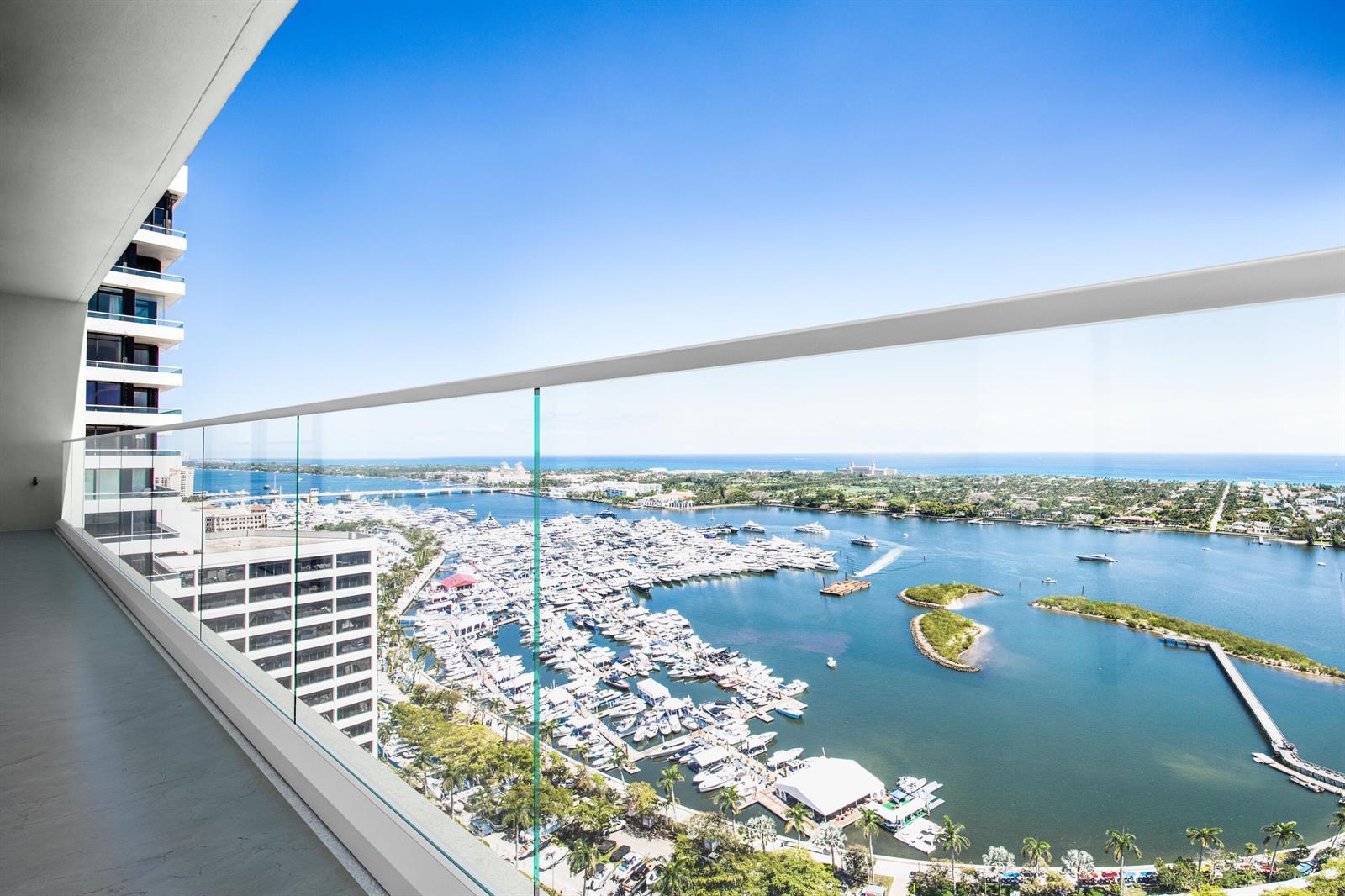 A high-rise balcony with a glass railing overlooks a marina filled with many boats — 529 S Flagler Drive, West Palm Beach FL 33401, WEST PALM BEACH, FL