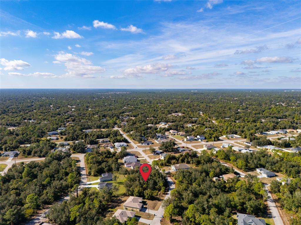An aerial view shows a red location pin marking a vacant lot in a neighborhood — JODY AVENUE, NORTH PORT, FL