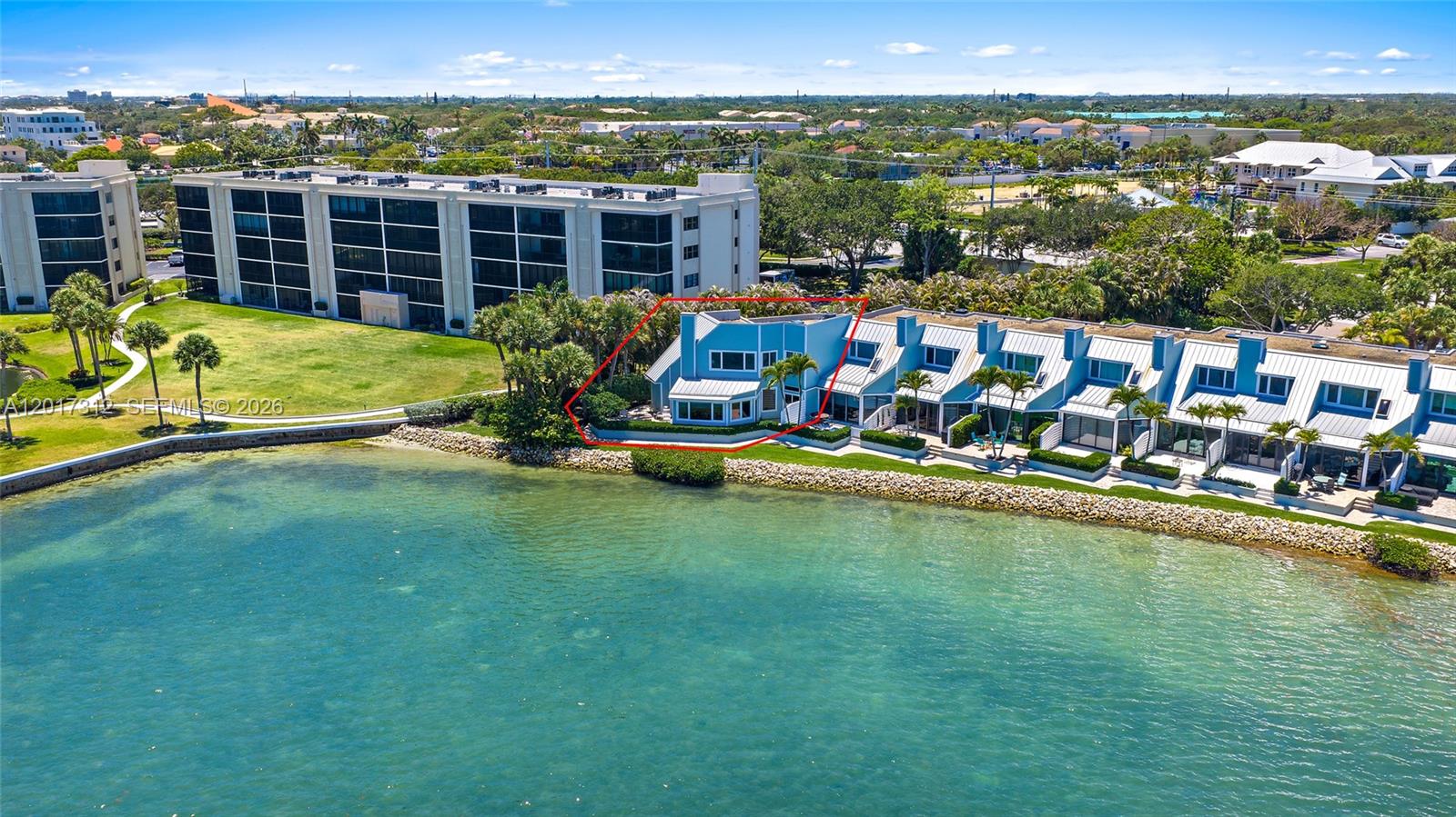 An aerial view shows a blue waterfront townhouse with a red outline on the exterior — 19932 Scrimshaw Way, Jupiter FL 33469, JUPITER, FL