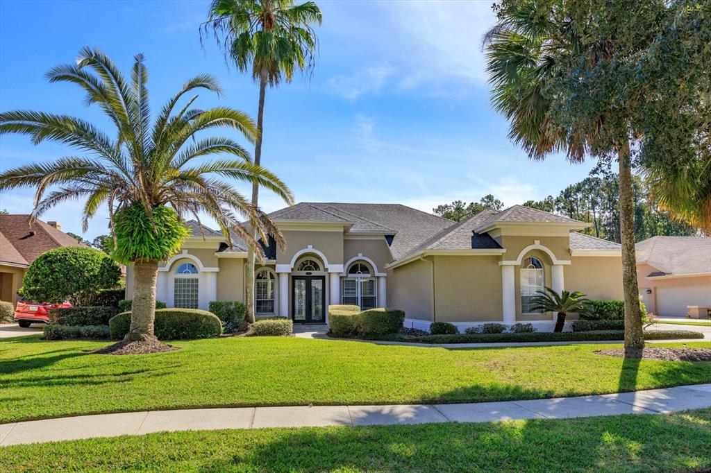 A single-story tan house with a gray roof and palm trees in the front yard — 5341 FAWN WOODS COURT, SANFORD, FL