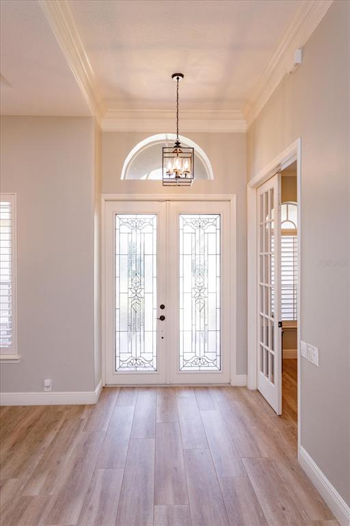 An entryway features double glass-paneled doors, a hanging lantern light, and light-colored wood flooring — 5341 FAWN WOODS COURT, SANFORD, FL