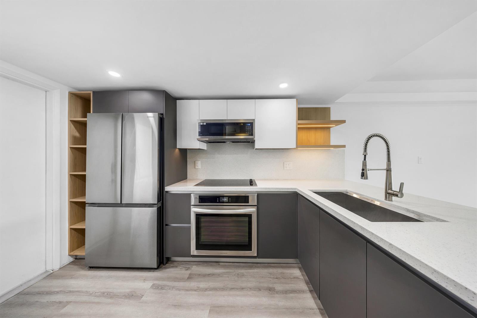 A modern kitchen features dark grey lower cabinets, white upper cabinets, and stainless steel appliances — 3151 S Palm Aire Drive # 407, Pompano Beach FL 33069, POMPANO BEACH, FL