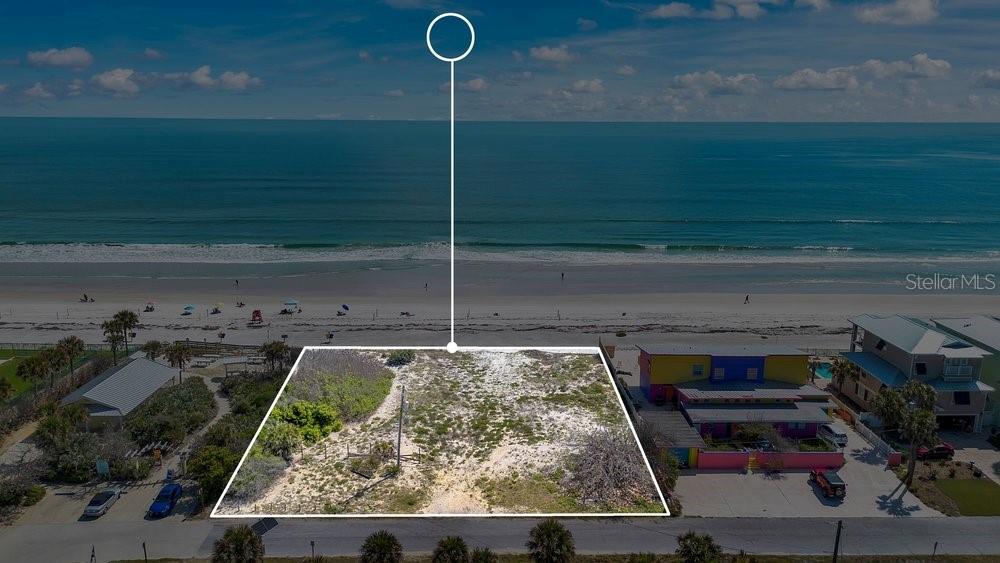 An aerial view shows a vacant, sandy beachside lot situated between two houses — 4591 S ATLANTIC AVENUE, PORT ORANGE, FL