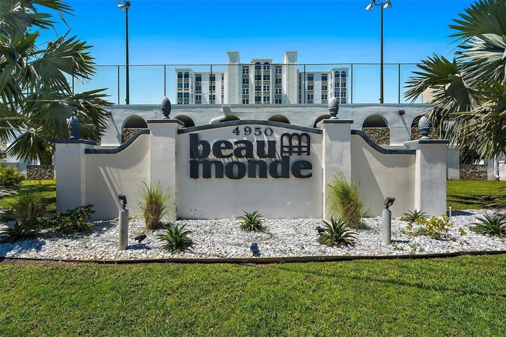 A white monument sign with the text "beau monde" stands in front of a tall building — 4950 GULF BOULEVARD UNIT 408, ST PETE BEACH, FL