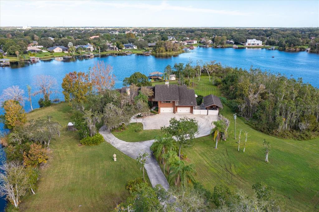 An aerial view of a house with a large driveway situated on a lakefront lot — 13377 LAKE BUTLER BOULEVARD, WINTER GARDEN, FL