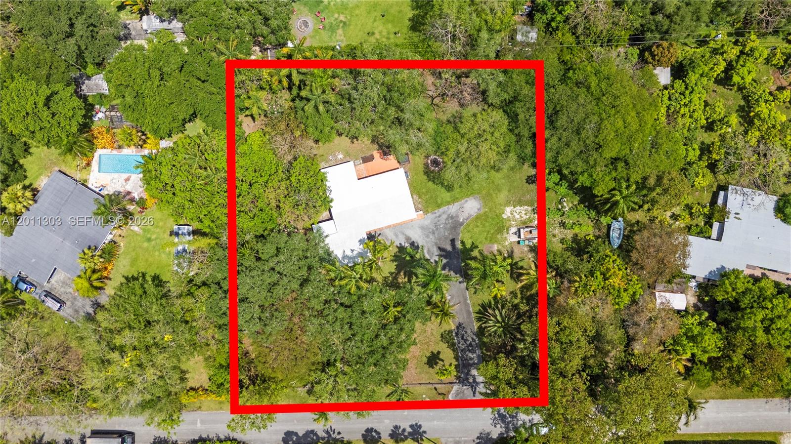 An aerial view shows a house with a white roof surrounded by dense trees — 15345 SW 269th Ter, Homestead FL 33032, HOMESTEAD, FL