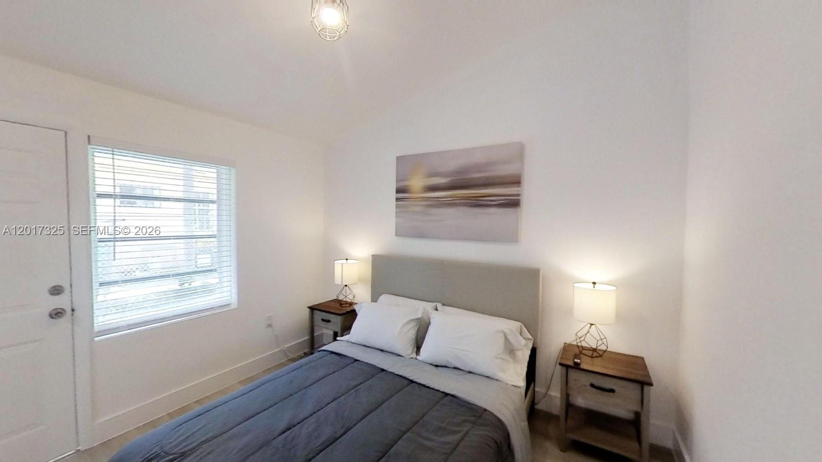 A bedroom features a bed with a gray headboard, two nightstands, and a window — 840 SW 7th St # 852, Miami FL 33130, MIAMI, FL