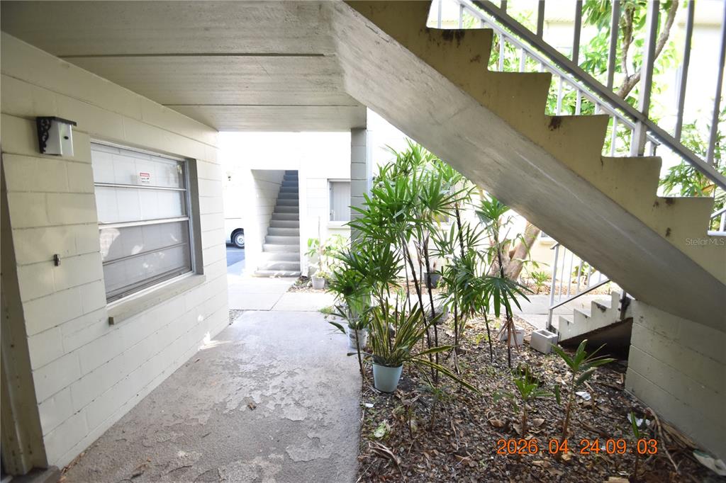 An outdoor walkway passes beneath a concrete staircase leading to an apartment building entrance — 306 DANUBE AVENUE UNIT 2, TAMPA, FL