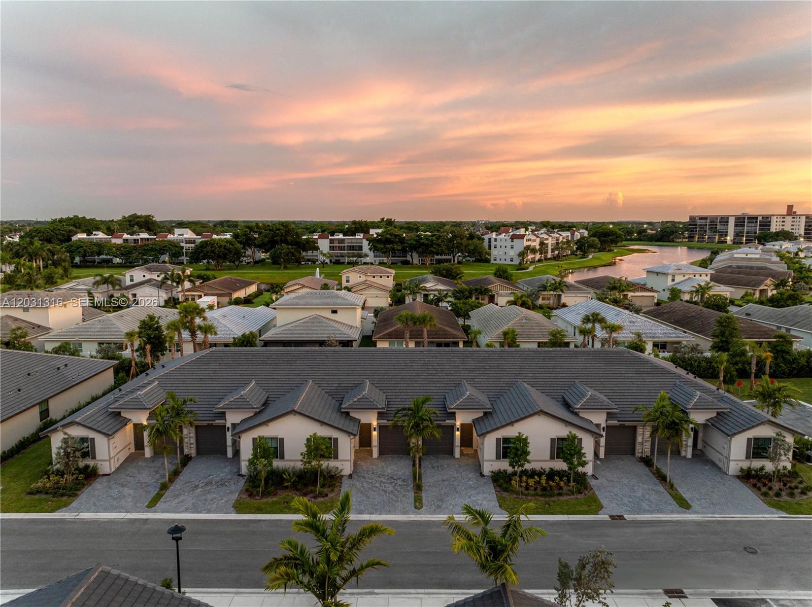 An aerial view shows a row of attached single-story houses with gray roofs at sunset — 7305 Ivory Spring, Delray Beach FL 33446, DELRAY BEACH, FL