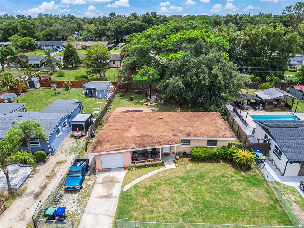 An aerial view shows a single-story house with a flat roof, driveway, and backyard — 3402 NEEDLES DRIVE, ORLANDO, FL
