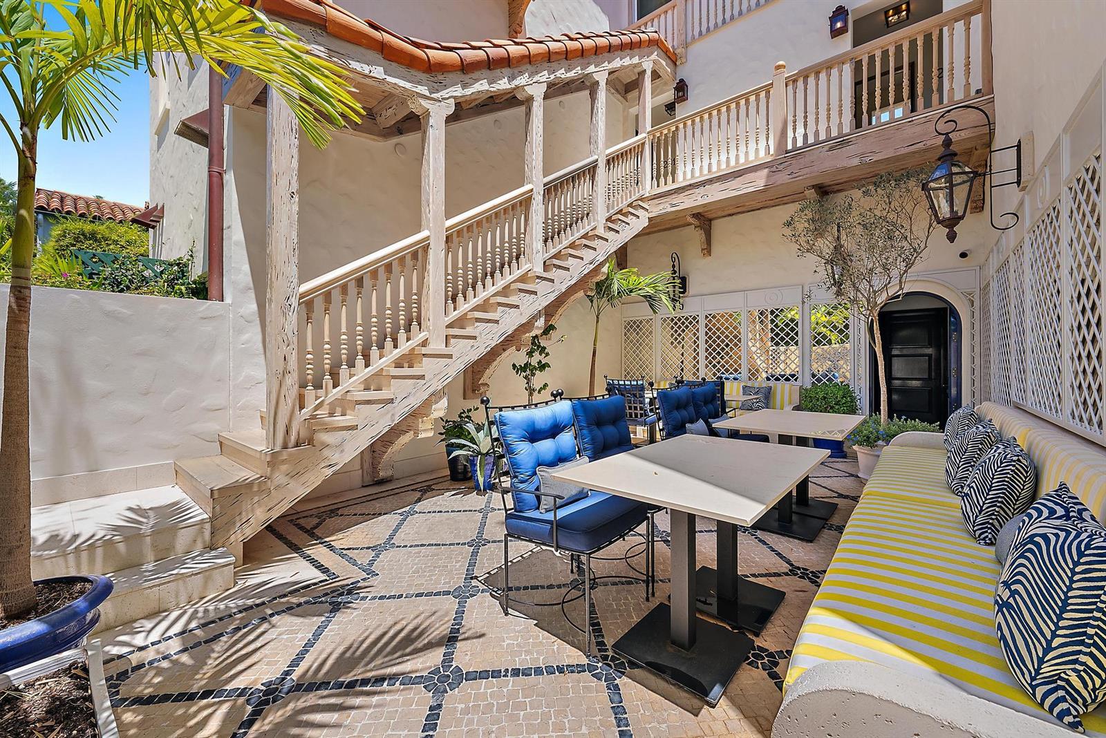 An outdoor patio features a wooden staircase, tiled flooring, dining tables, and a striped bench — 236 Phipps Plaza # 101, Palm Beach FL 33480, PALM BEACH, FL