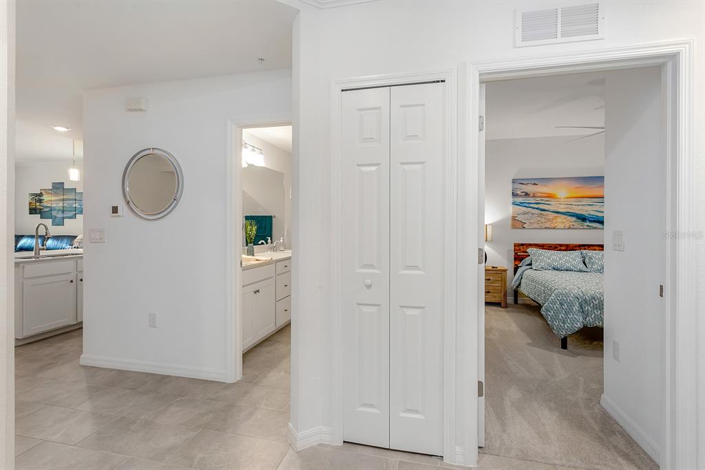 A hallway with tile flooring leads to a bathroom, a closet, and a carpeted bedroom — 18028 GAWTHROP DRIVE UNIT 108, BRADENTON, FL