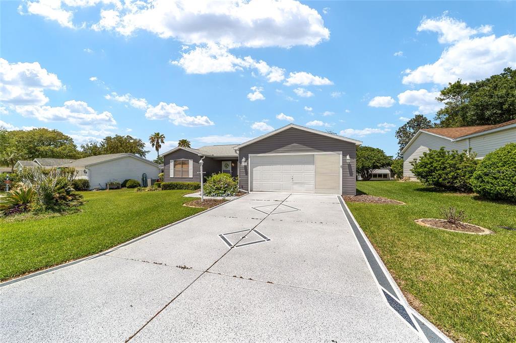 A single-story house with a gray exterior, a two-car garage, and a concrete driveway — 435 SANTA CLARA CIRCLE, THE VILLAGES, FL
