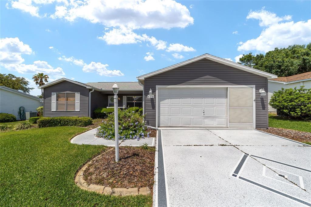A single-story house with gray siding, a two-car garage, and a front yard — 435 SANTA CLARA CIRCLE, THE VILLAGES, FL