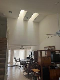A high-ceilinged living and dining area features two skylights, tiled floors, and a staircase — 1010 Landings Boulevard, FL 33413, FL
