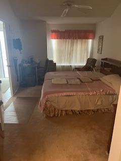 A bedroom features a bed with a pink cover, a desk, and a window with curtains — 1010 Landings Boulevard, FL 33413, FL