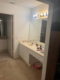 A bathroom vanity with a white cabinet, countertop, and mirror sits next to a doorway — 1010 Landings Boulevard, FL 33413, FL