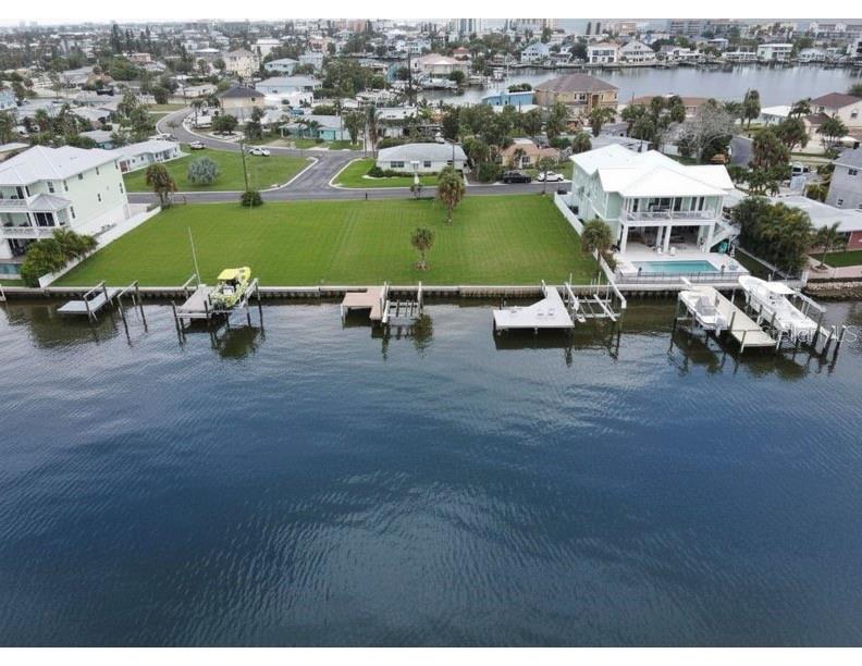 An aerial view shows a large waterfront lot with a house, pool, and multiple docks — 14217 E PARSLEY DRIVE, ST PETERSBURG, FL