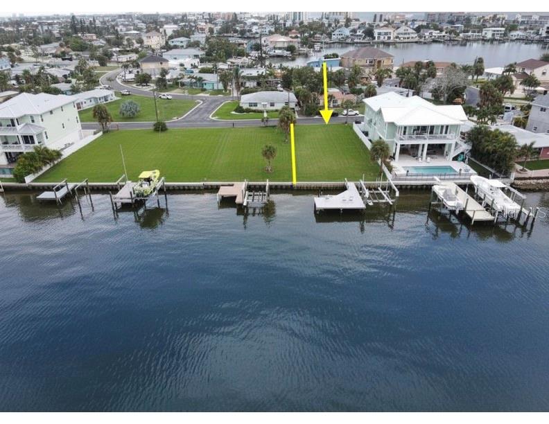 An aerial view shows a vacant waterfront lot situated between two houses with private docks — 14217 E PARSLEY DRIVE, ST PETERSBURG, FL
