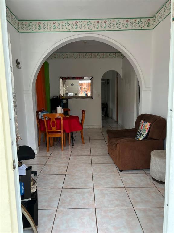 A dining area with a red tablecloth and a brown armchair sit under an arched entryway — 258 H BARTOLOME DE LAS CASAS, SANTURCE, SAN JUAN, PR