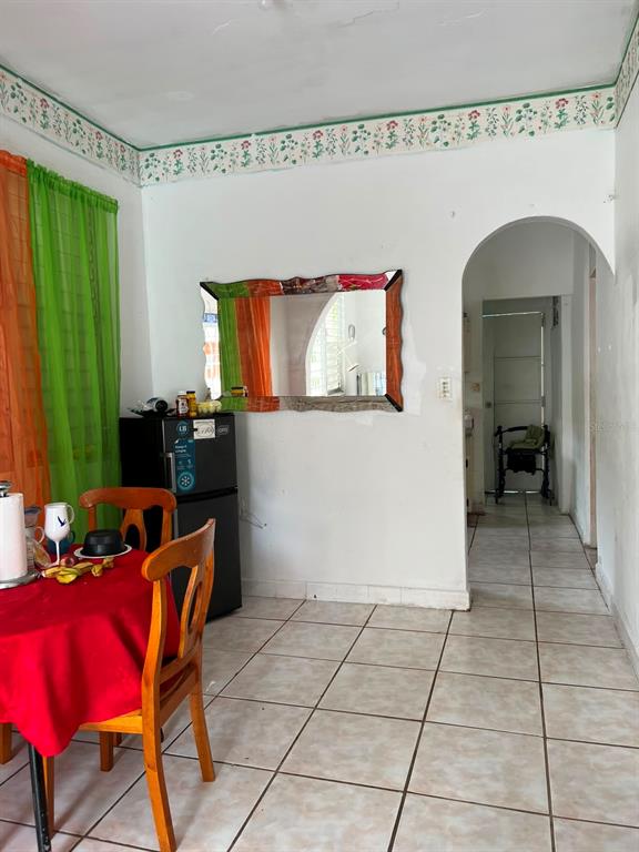 A dining area with a red-clothed table, a small refrigerator, and an arched doorway — 258 H BARTOLOME DE LAS CASAS, SANTURCE, SAN JUAN, PR
