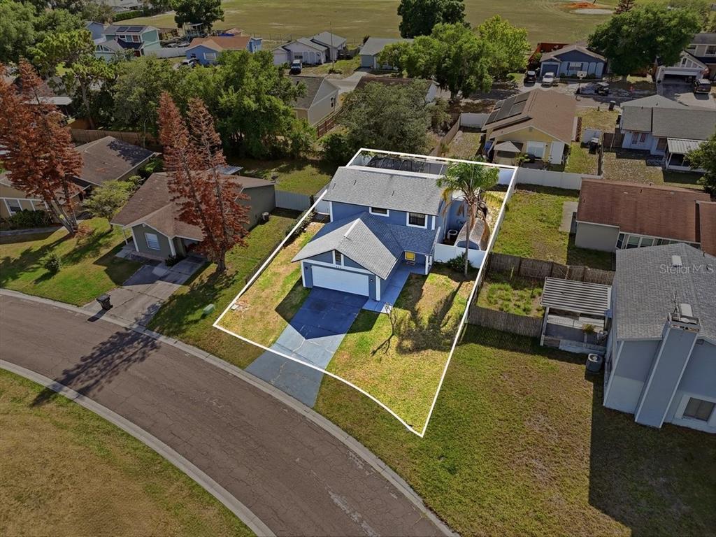 An aerial view shows a two-story house with a garage and a screened-in pool — 931 WHISPER LAKE DRIVE, WINTER HAVEN, FL