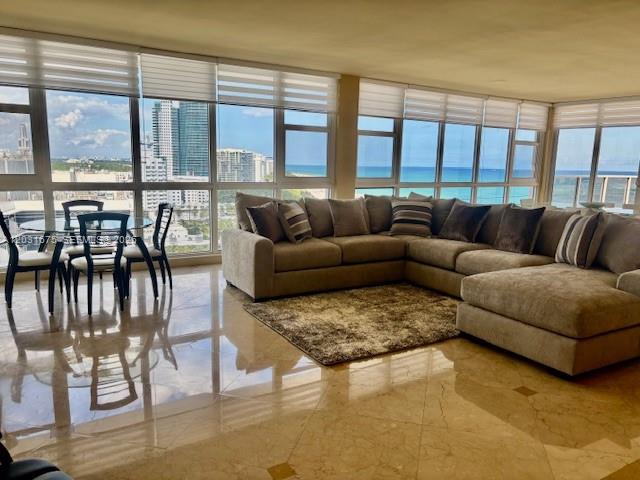 A living room with a large sectional sofa, dining set, and floor-to-ceiling ocean view windows — 100 Lincoln Rd, Miami Beach FL 33139, MIAMI BEACH, FL