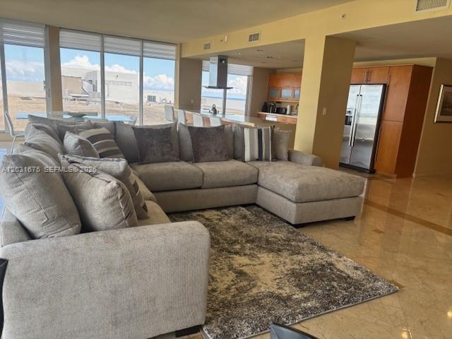 A large sectional sofa sits on a rug in an open-concept living room with kitchen — 100 Lincoln Rd, Miami Beach FL 33139, MIAMI BEACH, FL