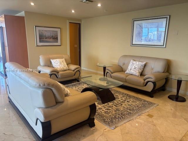 A living room features beige leather furniture, a glass coffee table, and a patterned rug — 100 Lincoln Rd, Miami Beach FL 33139, MIAMI BEACH, FL