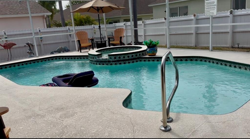A swimming pool with an attached spa and a patio area enclosed by a screen — 10632 LAKE VISTA DRIVE, SEMINOLE, FL